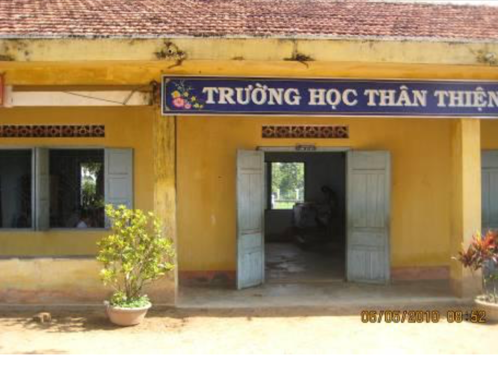 A yellow building with an open double door and windows labeled "Trưá»ng Há»c Thân Thiện" with a date stamp of 03/09/2010 08:51 AM at the bottom right corner.