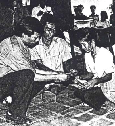 Ca Van Tran (I) at the rehabilitation clinic in Can Tho with a vetran of the South Vietnamese Army (ARVN who lost both legs during the war. Having neither artificial legs nor a wheelchair, the man must use the wooden block on which he is sitting as "hand crutches."
